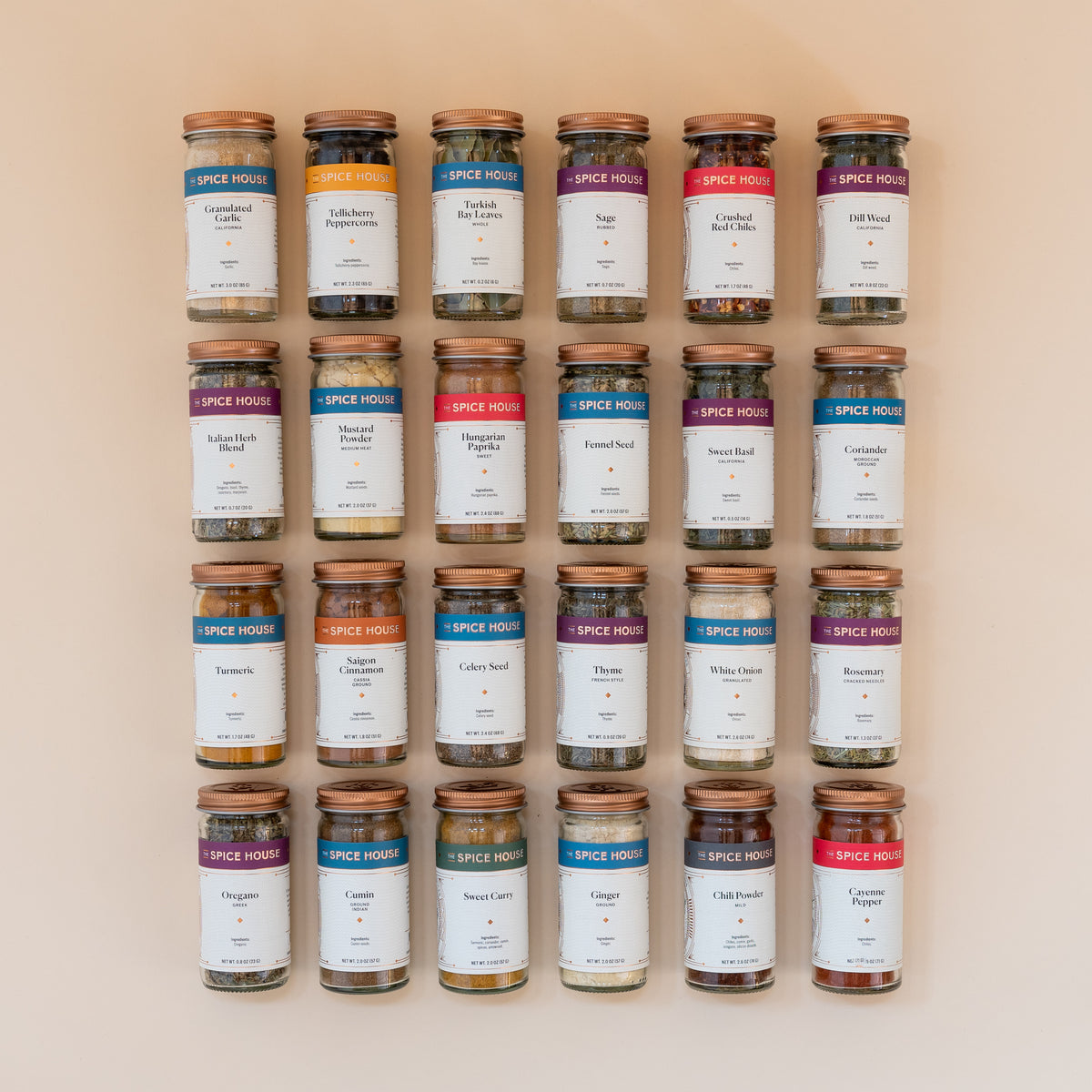 A set of small spice jars full with various colorful Indian